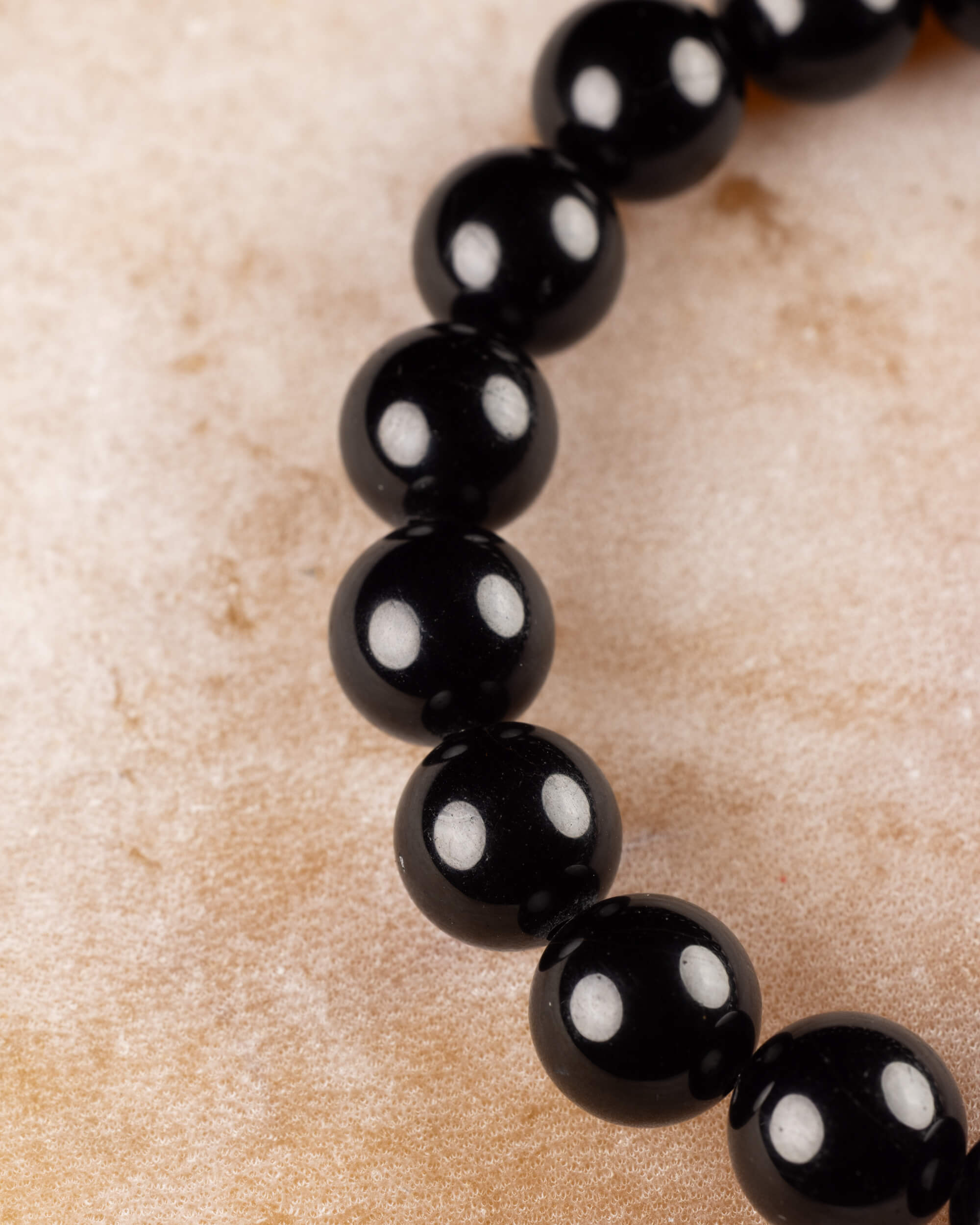 Detalle macro de las cuentas de Turmalina Negra de la pulsera en fila vertical