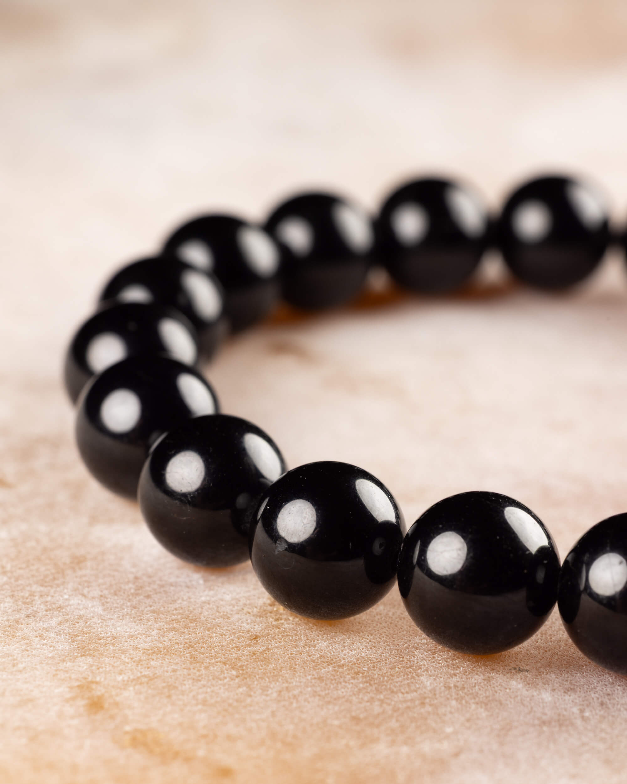 Pulsera de Turmalina Negra vista en ángulo, con sus cuentas redondas y brillantes