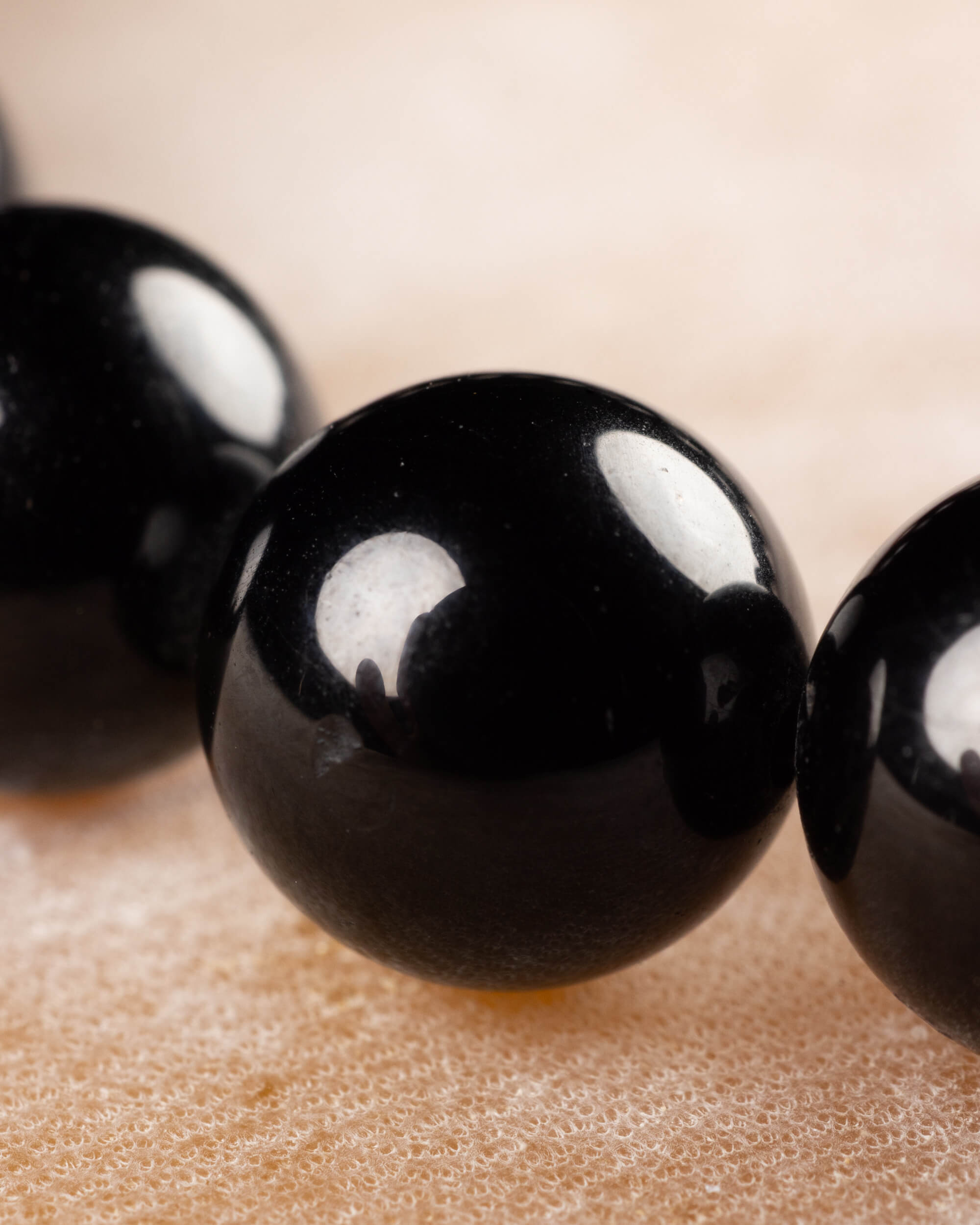 Detalle macro de las cuentas brillantes de Turmalina Negra de la pulsera