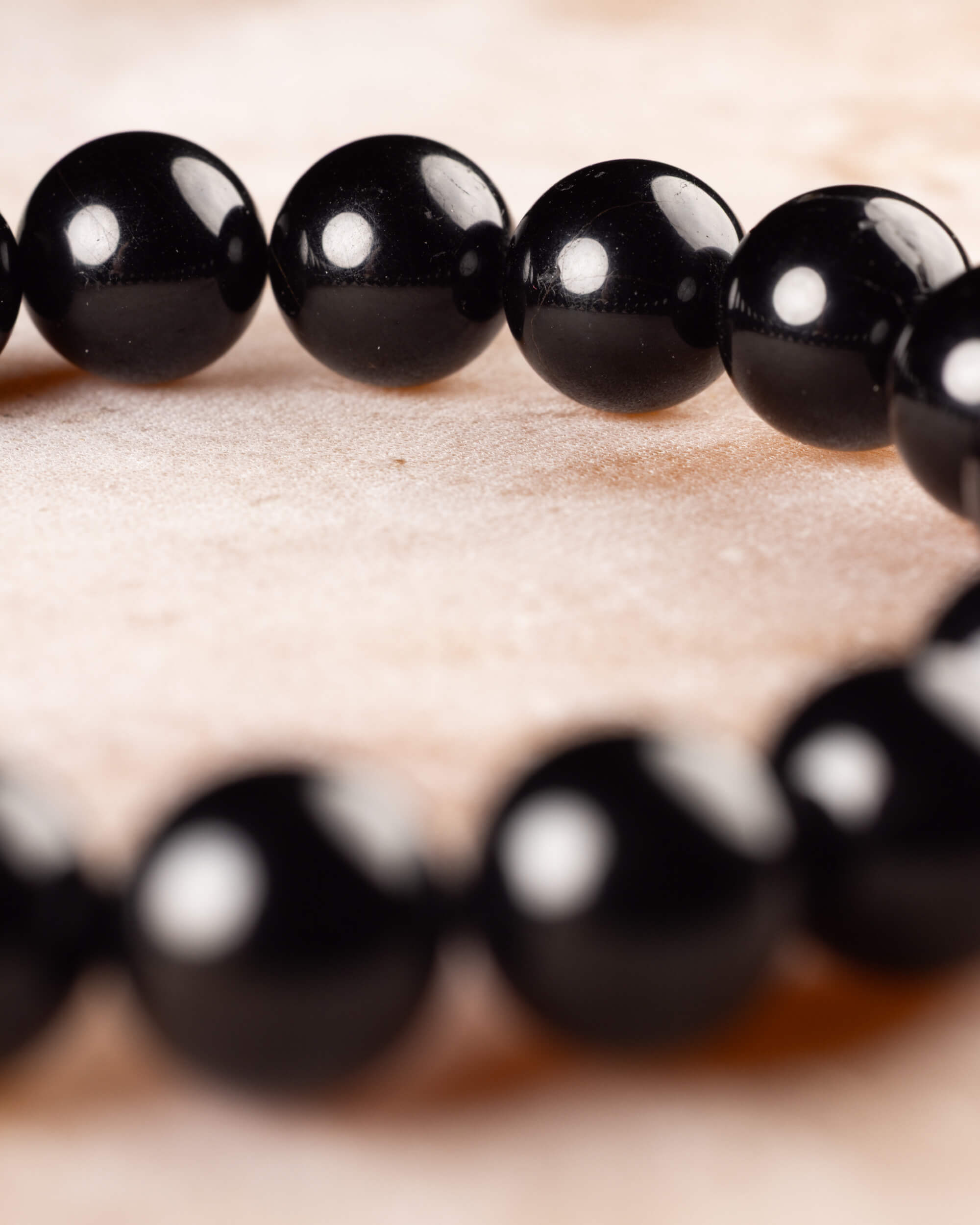Pulsera de Turmalina Negra vista de perfil cercano, con reflejos en sus cuentas