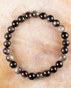 Pulsera de Obsidiana Plateada de 8 mm, pieza completa sobre superficie de mármol claro