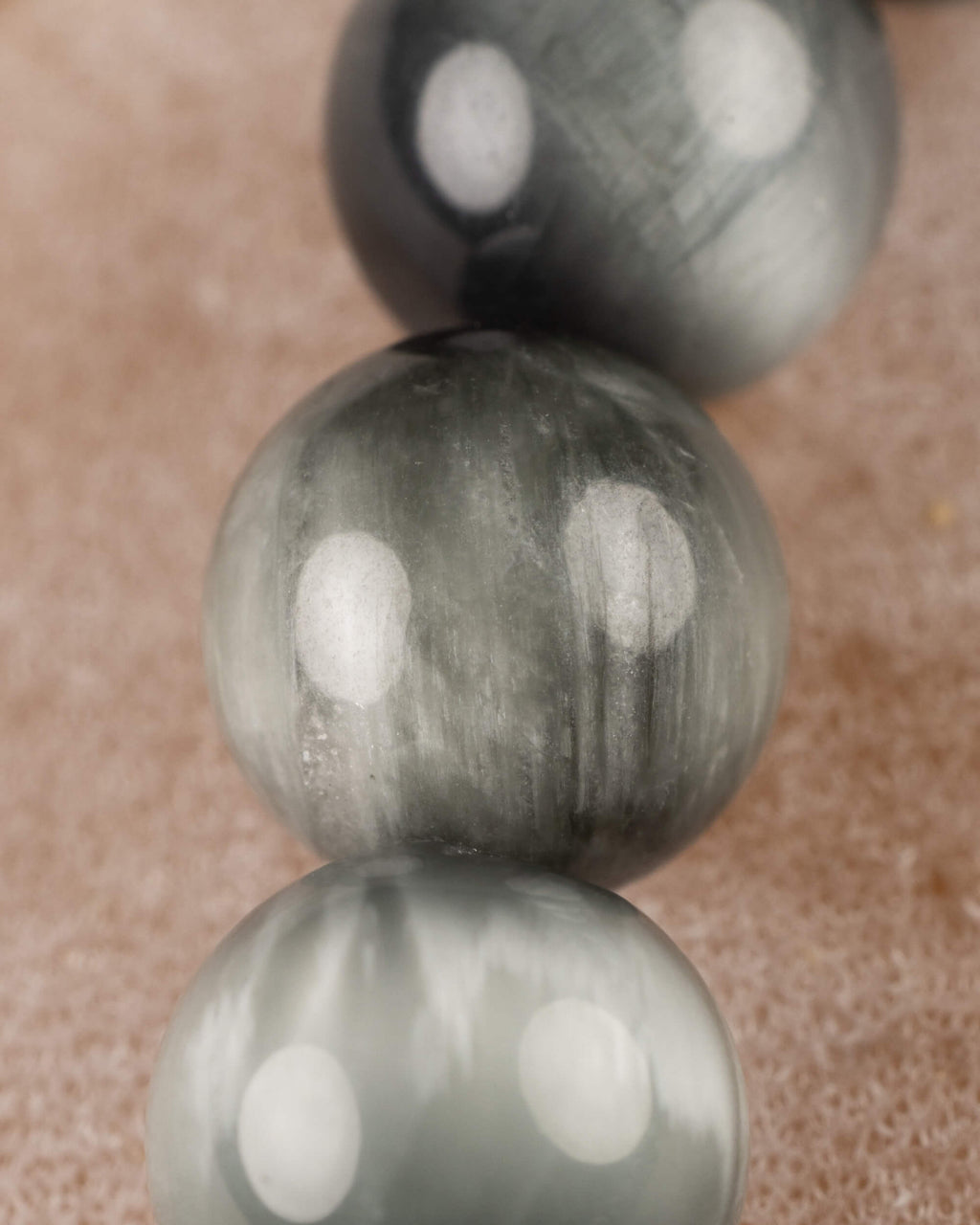 Detalle macro de las cuentas de Ojo de Halcon con vetas grises y plateadas