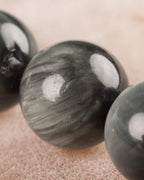 Detalle macro de una cuenta de Ojo de Halcon con vetas plateadas