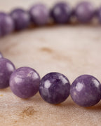 Pulsera de Lepidolita Uva vista de cerca en curva, tonos morados