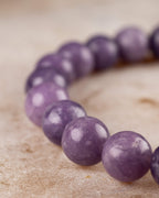 Pulsera de Lepidolita Uva en angulo curvo sobre superficie clara