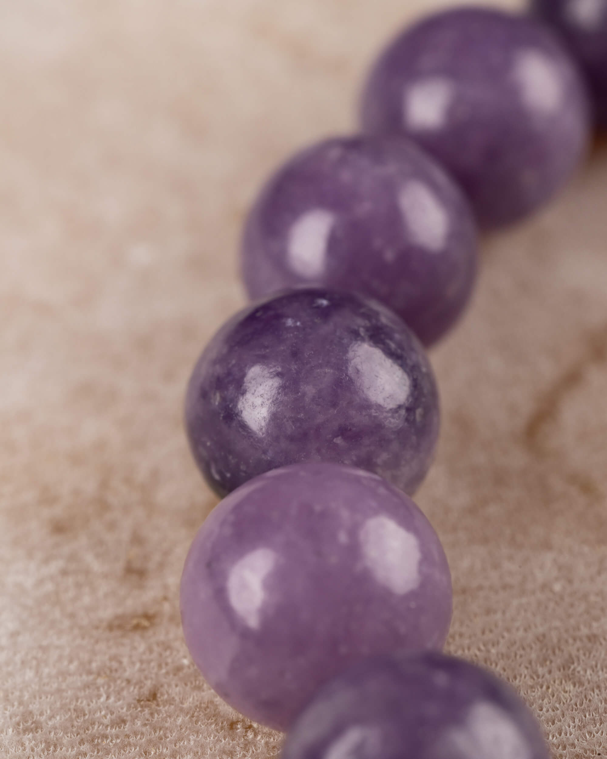 Pulsera de Lepidolita Uva en curva, detalle cercano de las cuentas