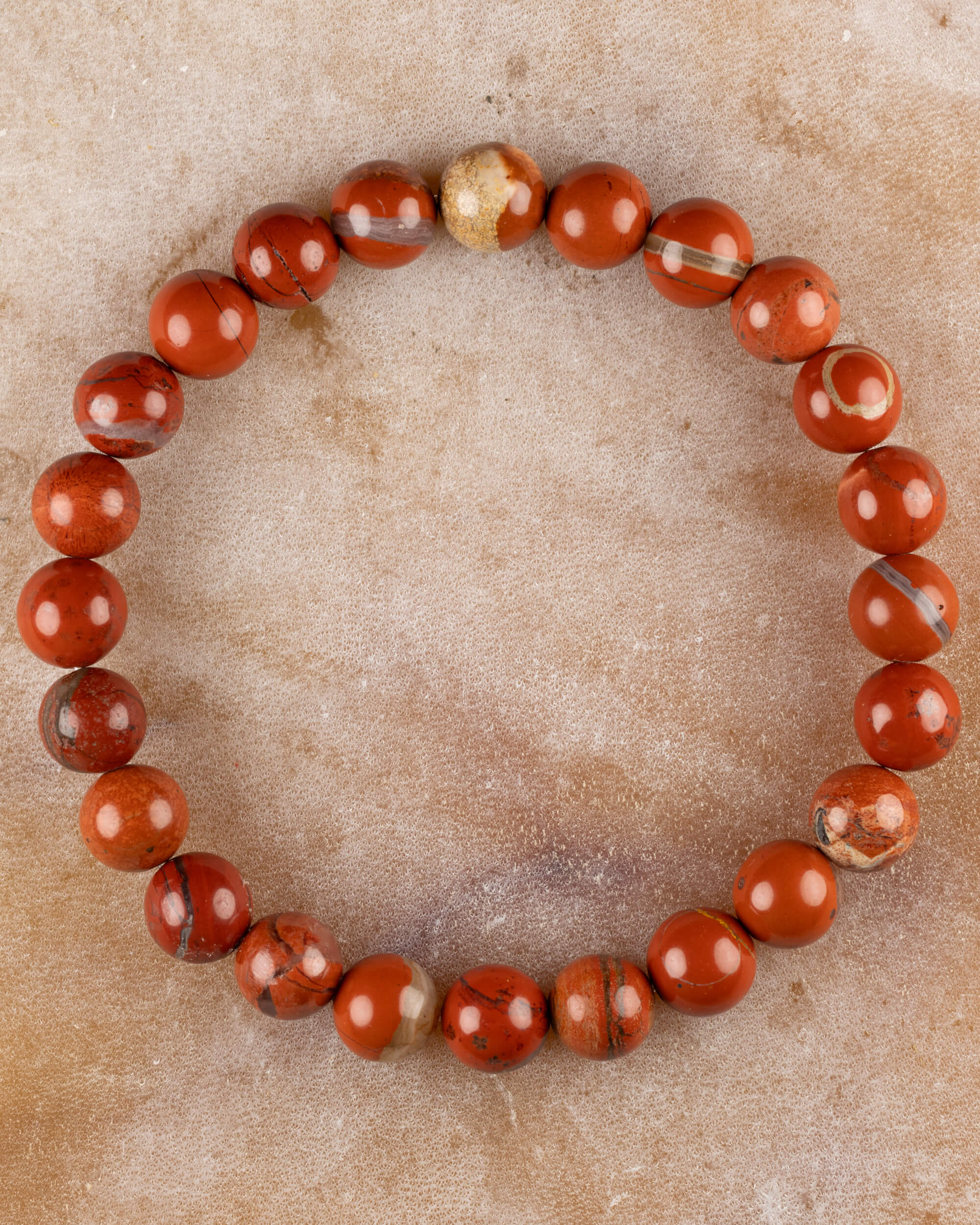 Pulsera de Jaspe Rojo, pieza completa sobre superficie de mármol claro