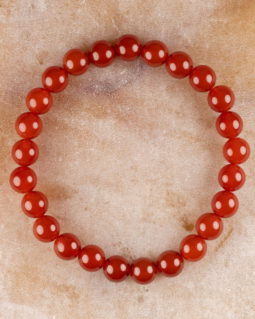 Pulsera de Cornalina de 8 mm, pieza completa en círculo sobre superficie de mármol claro