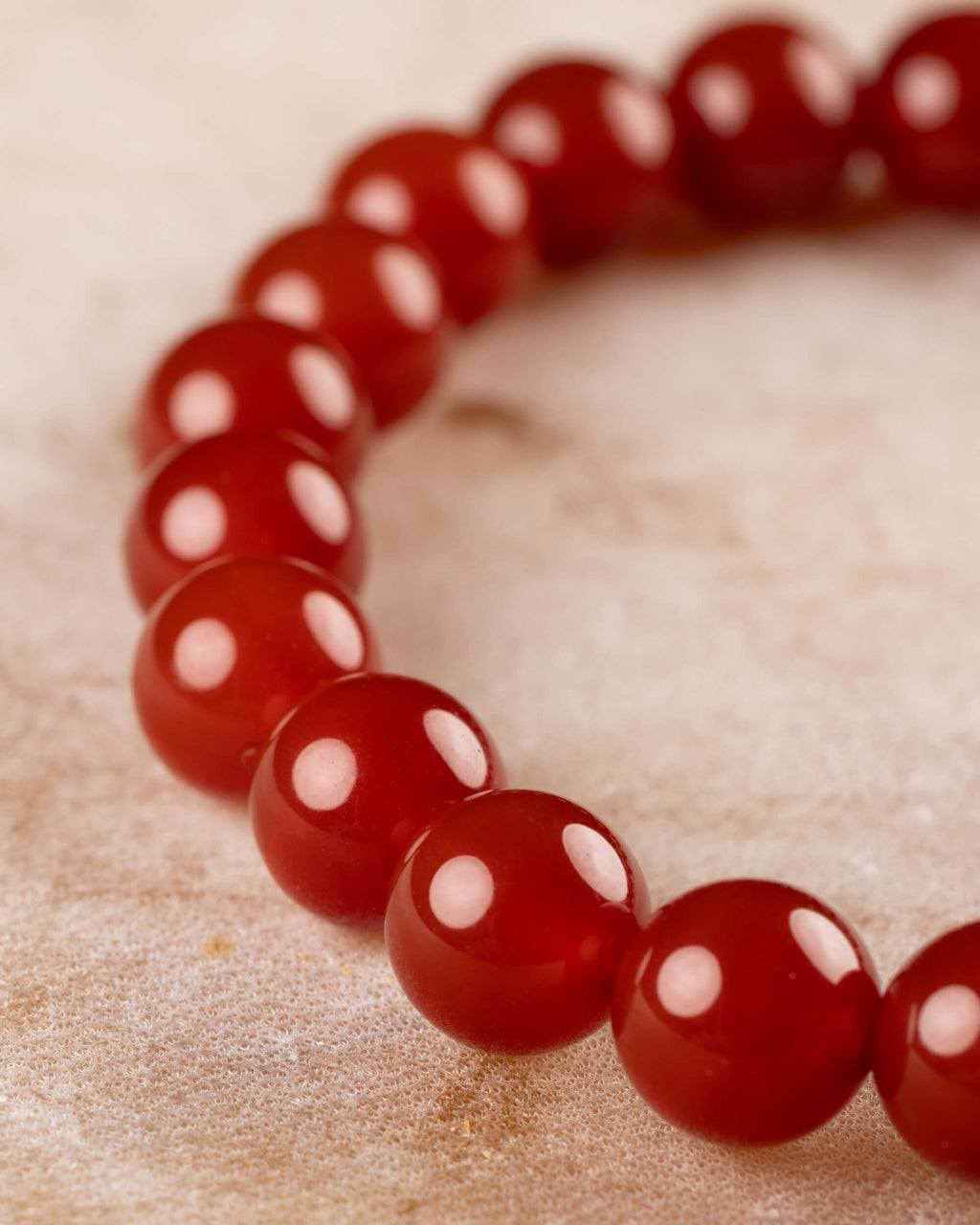 Pulsera de Cornalina en curva, cuentas alineadas sobre superficie clara