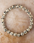 Pulsera de Jaspe Dalmata de 8 mm, pieza completa sobre superficie de piedra clara
