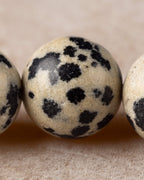 Detalle macro de una cuenta de Jaspe Dalmata con manchas negras marcadas