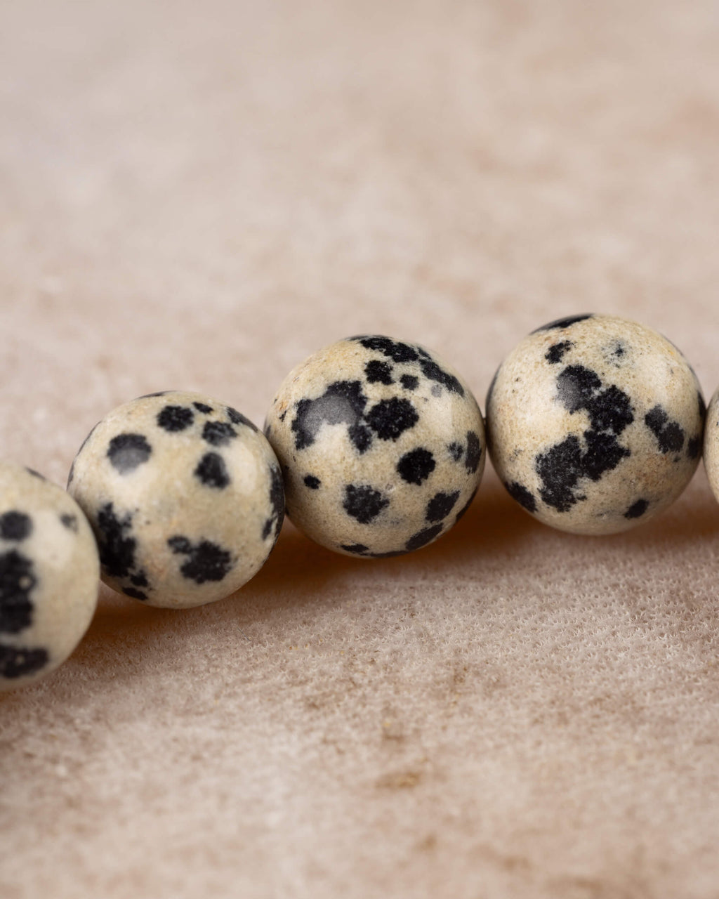 Primer plano de cuentas de Jaspe Dalmata, manchas negras sobre crema