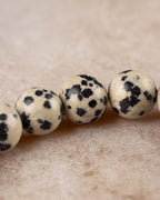 Primer plano de cuentas de Jaspe Dalmata, manchas negras sobre crema