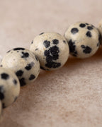 Detalle cercano de una cuenta de Jaspe Dalmata con manchas densas oscuras