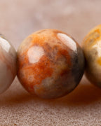 Detalle macro de cuenta de Ágata Mexicana con manchas naranja y gris