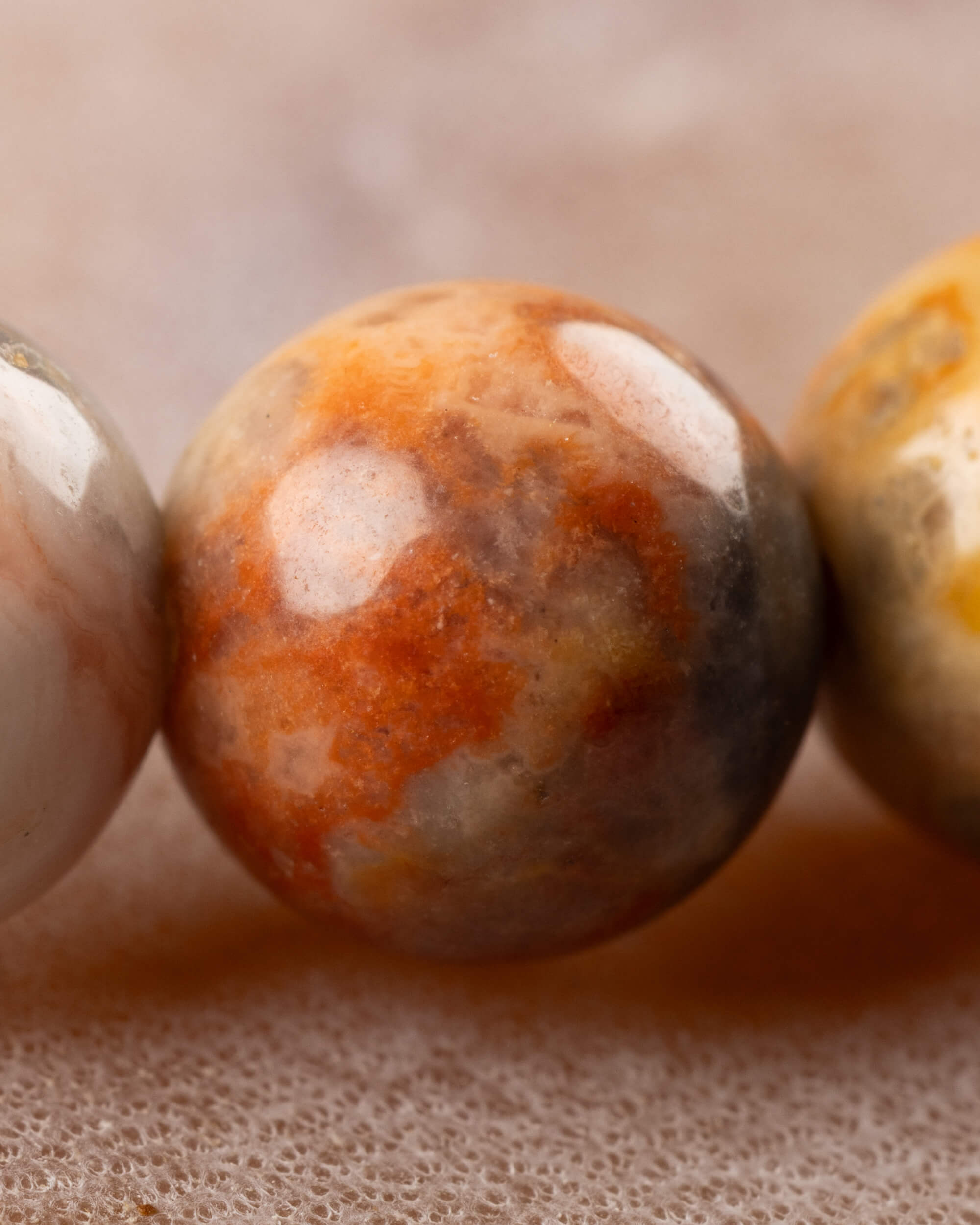 Detalle macro de cuenta de Ágata Mexicana con manchas naranja y gris