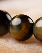 Detalle macro de las cuentas de Ojo de Tigre Bicolor en tonos dorado y negro