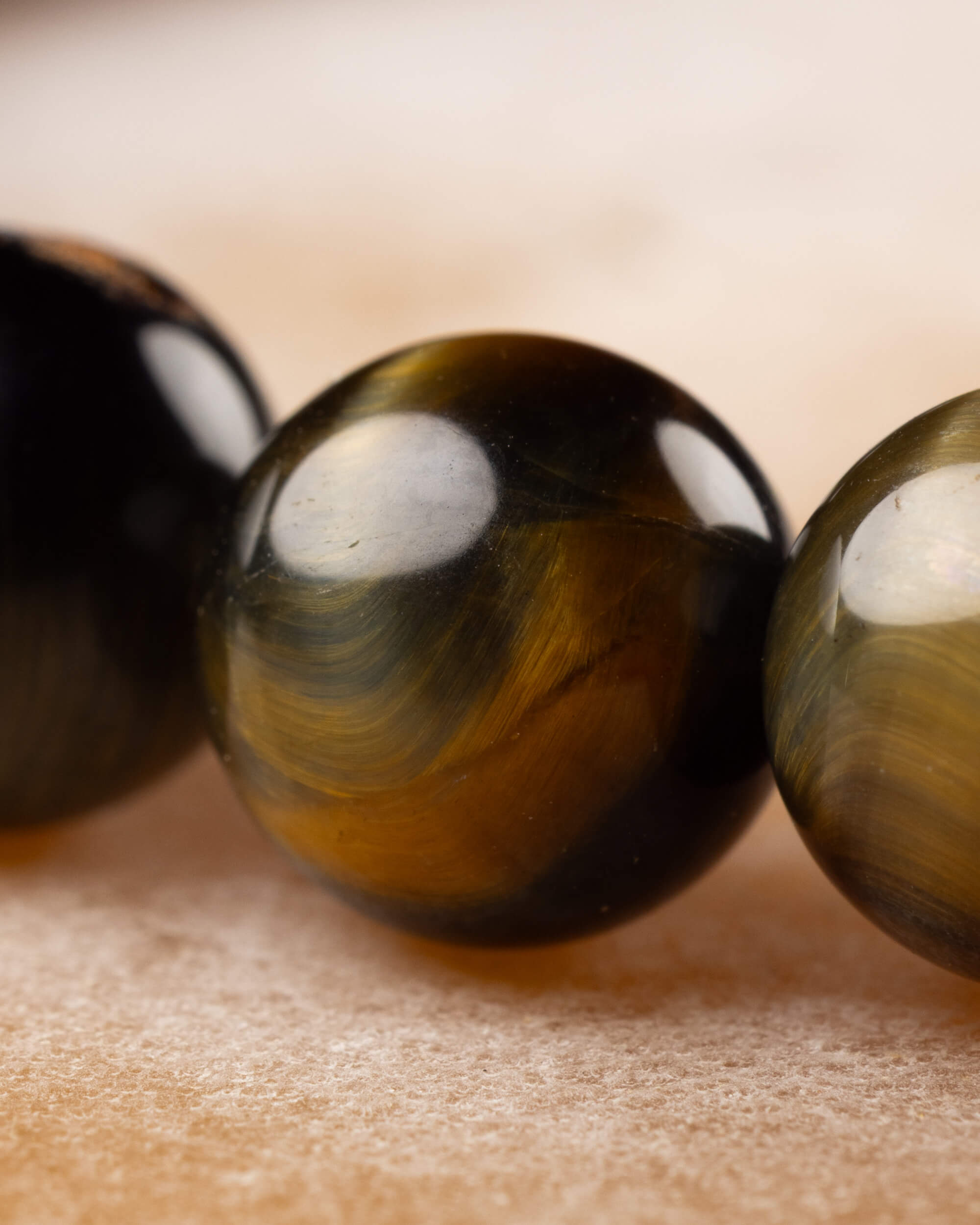 Detalle macro de las cuentas de Ojo de Tigre Bicolor en tonos dorado y negro