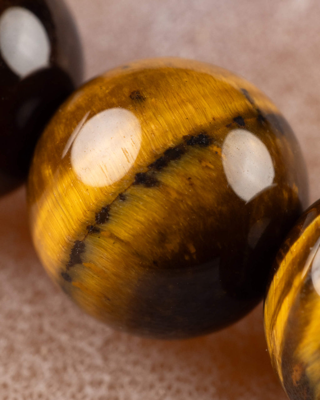Detalle macro de cuenta de Ojo de Tigre, vetas doradas y brillo caracteristico