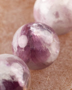 Detalle macro de una cuenta de Turmalina Ciruela con vetas moradas y blancas