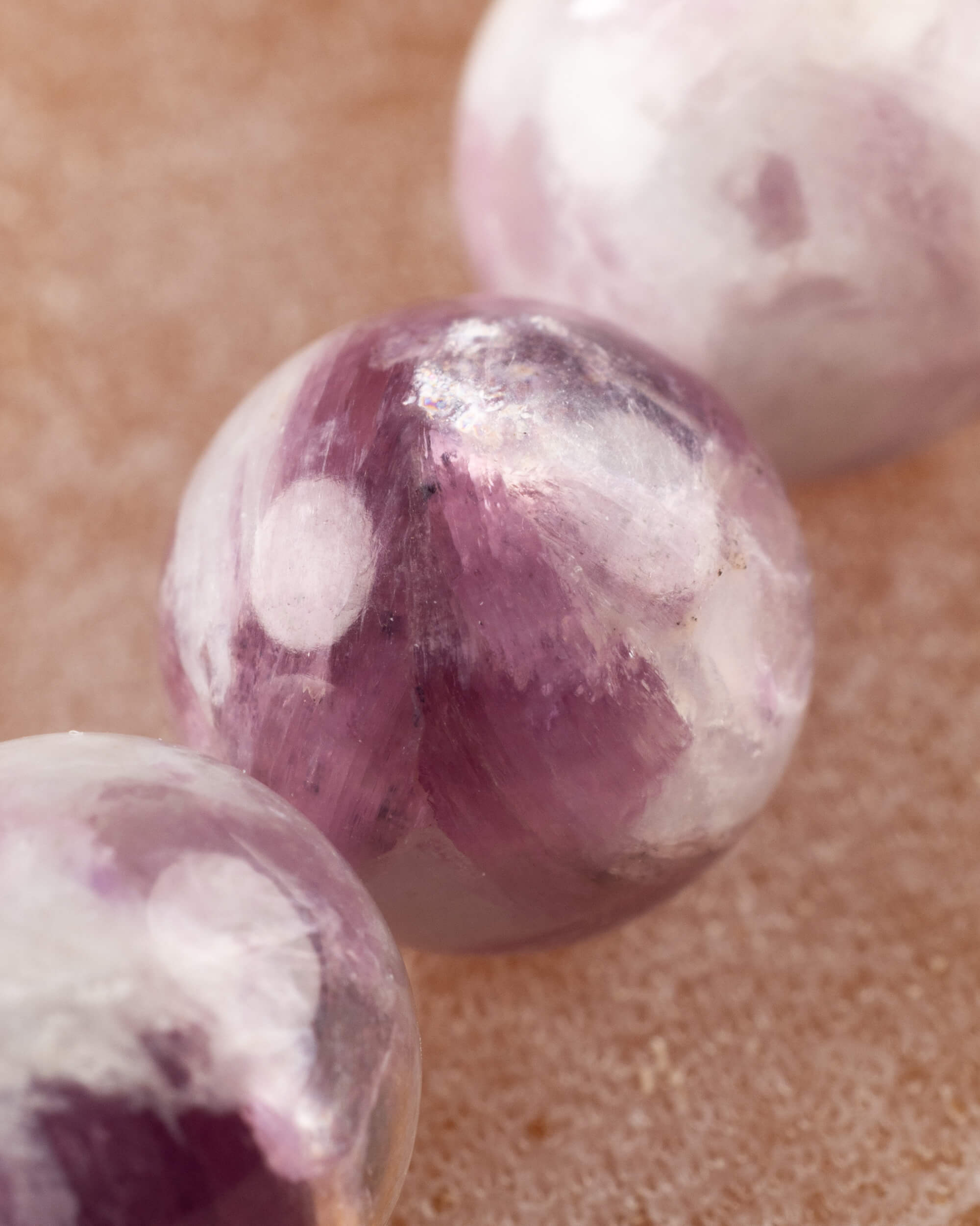 Detalle macro de una cuenta de Turmalina Ciruela con vetas moradas y blancas