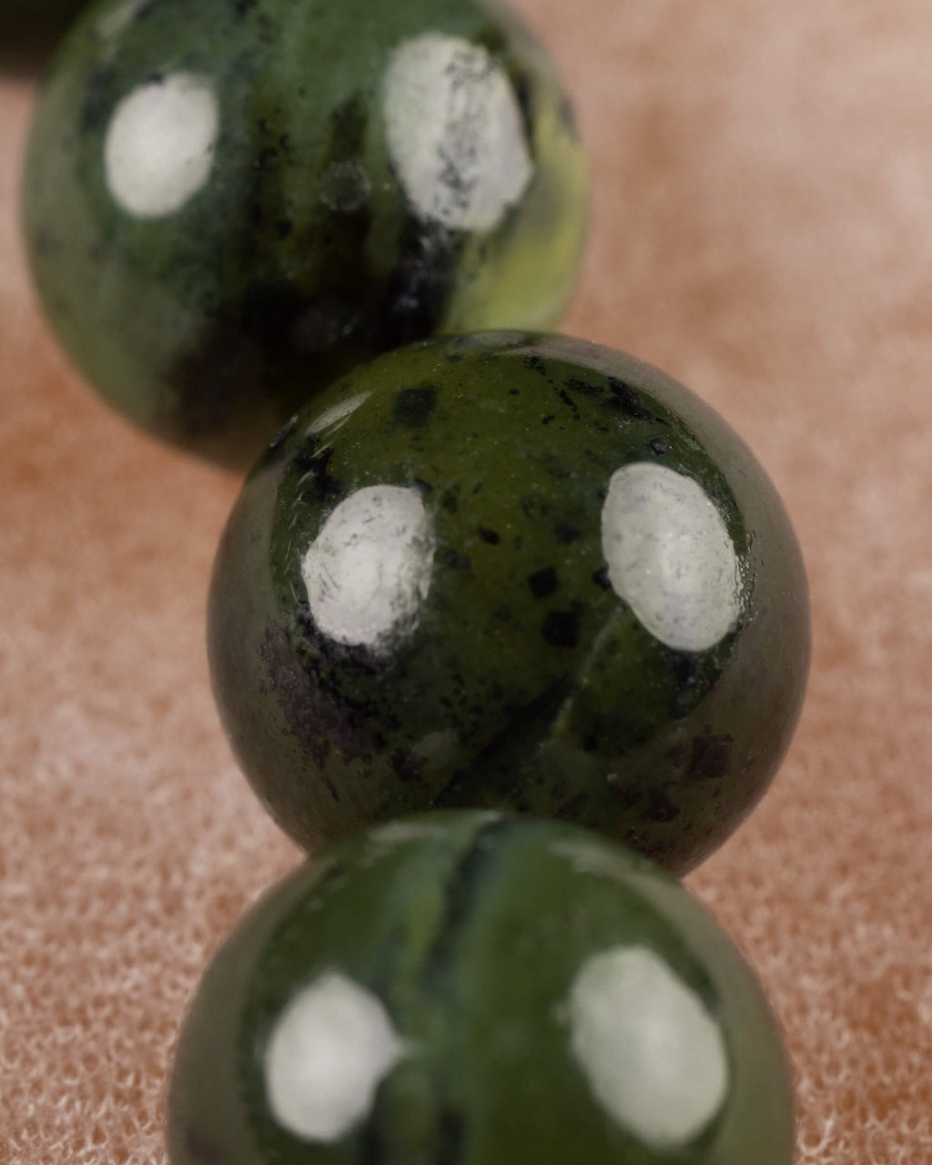Detalle macro de las cuentas de Jade Verde Oscuro con vetas y manchas claras