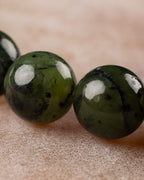 Detalle macro en primer plano de dos cuentas de Jade Verde Oscuro