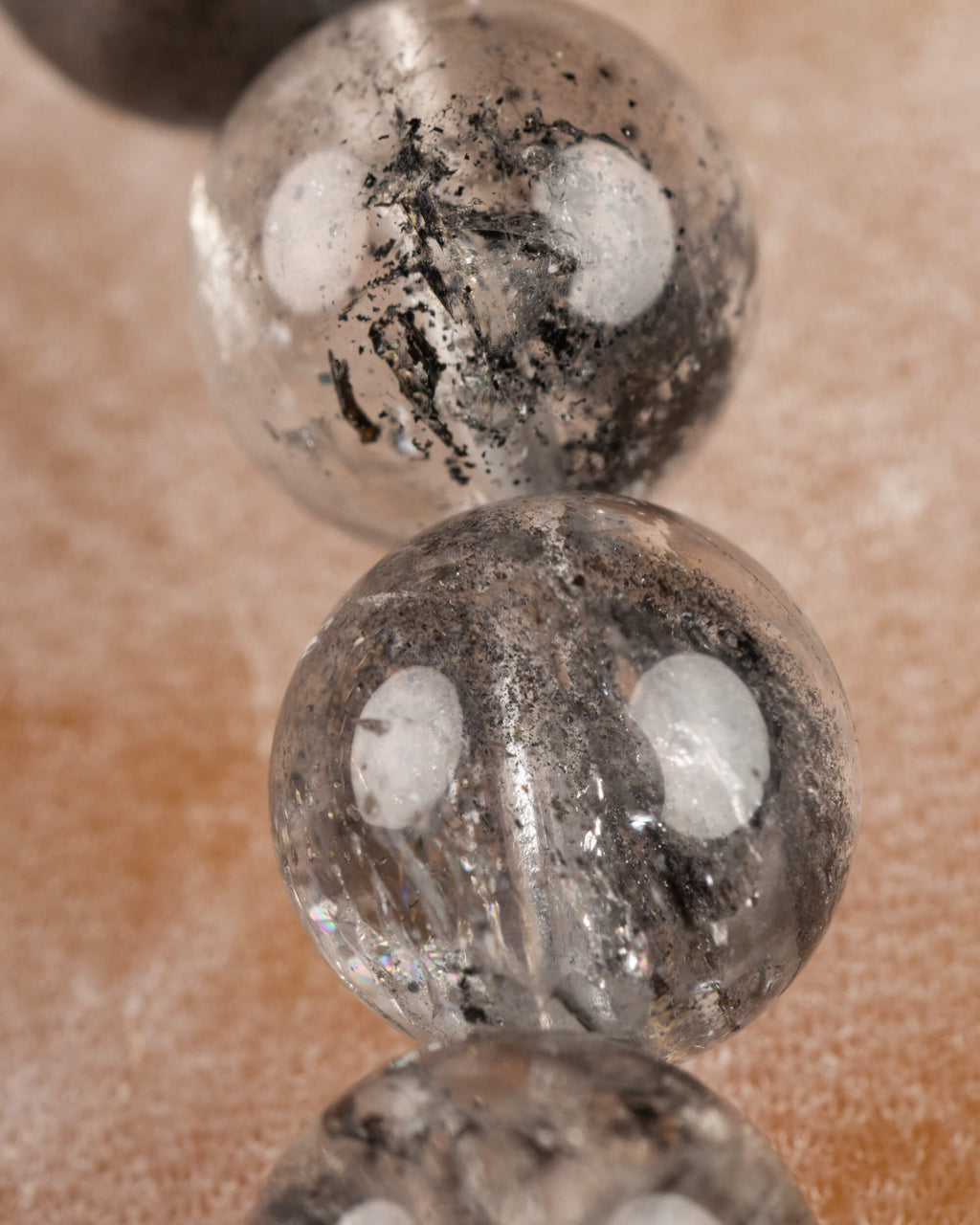 Detalle macro de una cuenta de Cuarzo Diamante de Herkimer con vetas negras marcadas