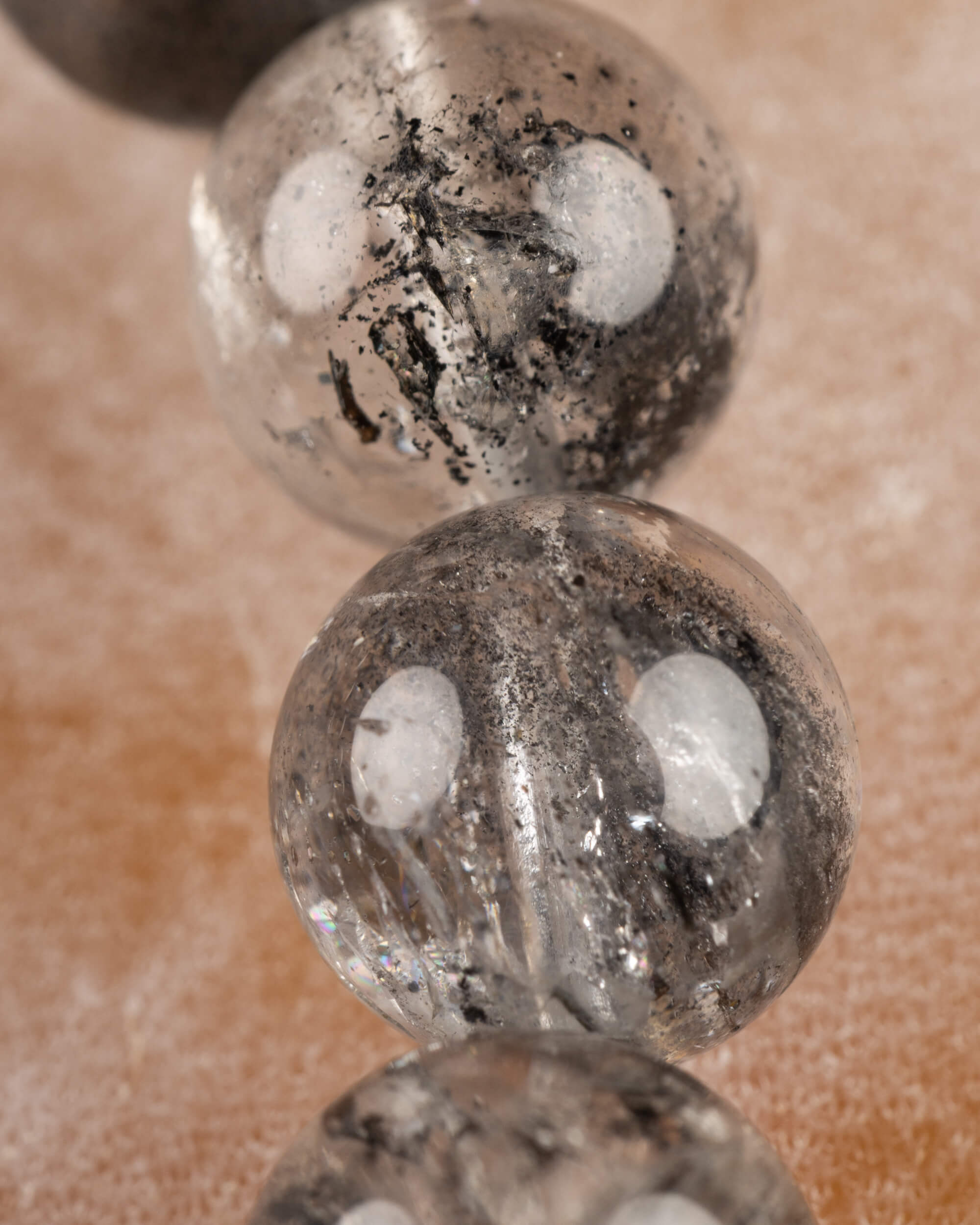 Detalle macro de una cuenta de Cuarzo Diamante de Herkimer con vetas negras marcadas