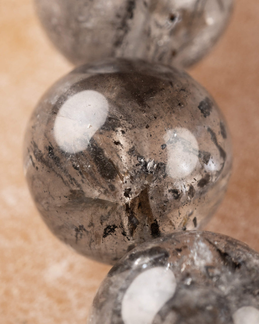 Detalle macro de una cuenta de Cuarzo Diamante de Herkimer con inclusiones negras