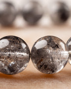 Detalle macro de cuentas de Cuarzo Diamante de Herkimer con inclusiones negras marcadas