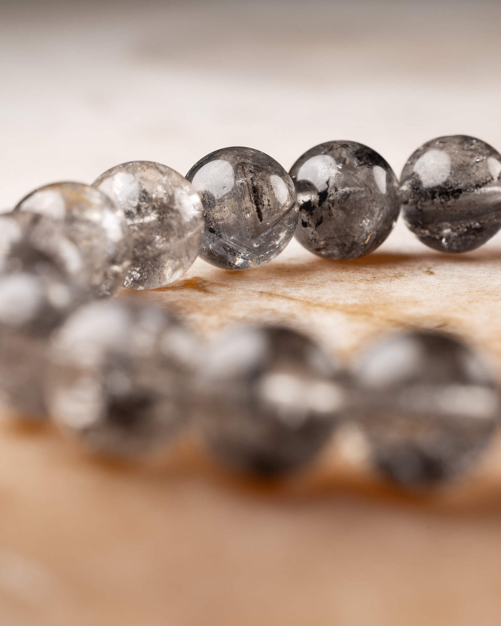 Pulsera de Cuarzo Diamante de Herkimer en curva, vista cercana de sus cuentas grisáceas