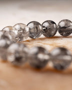 Pulsera de Cuarzo Diamante de Herkimer en curva, vista cercana de sus cuentas grisáceas