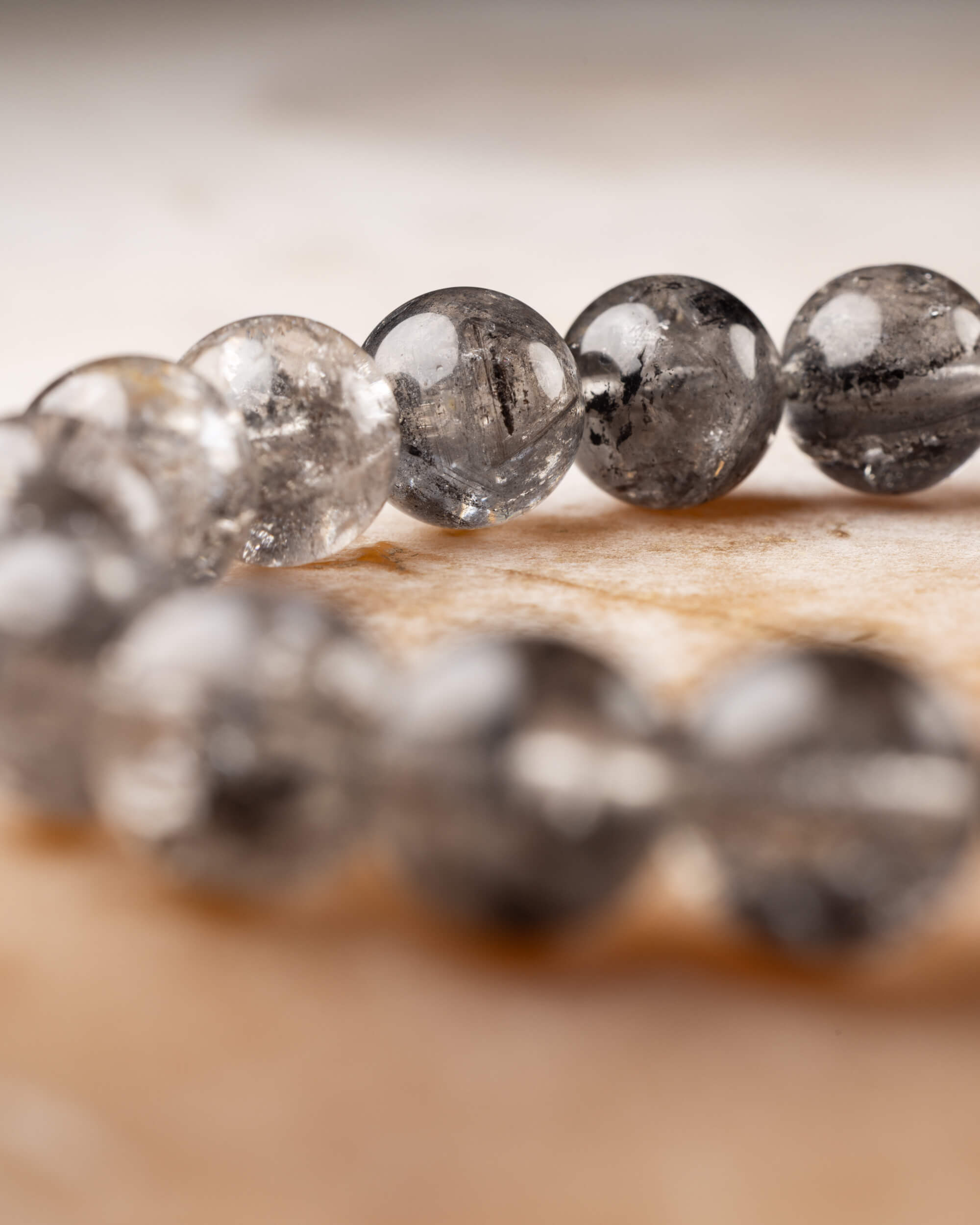 Pulsera de Cuarzo Diamante de Herkimer en curva, vista cercana de sus cuentas grisáceas