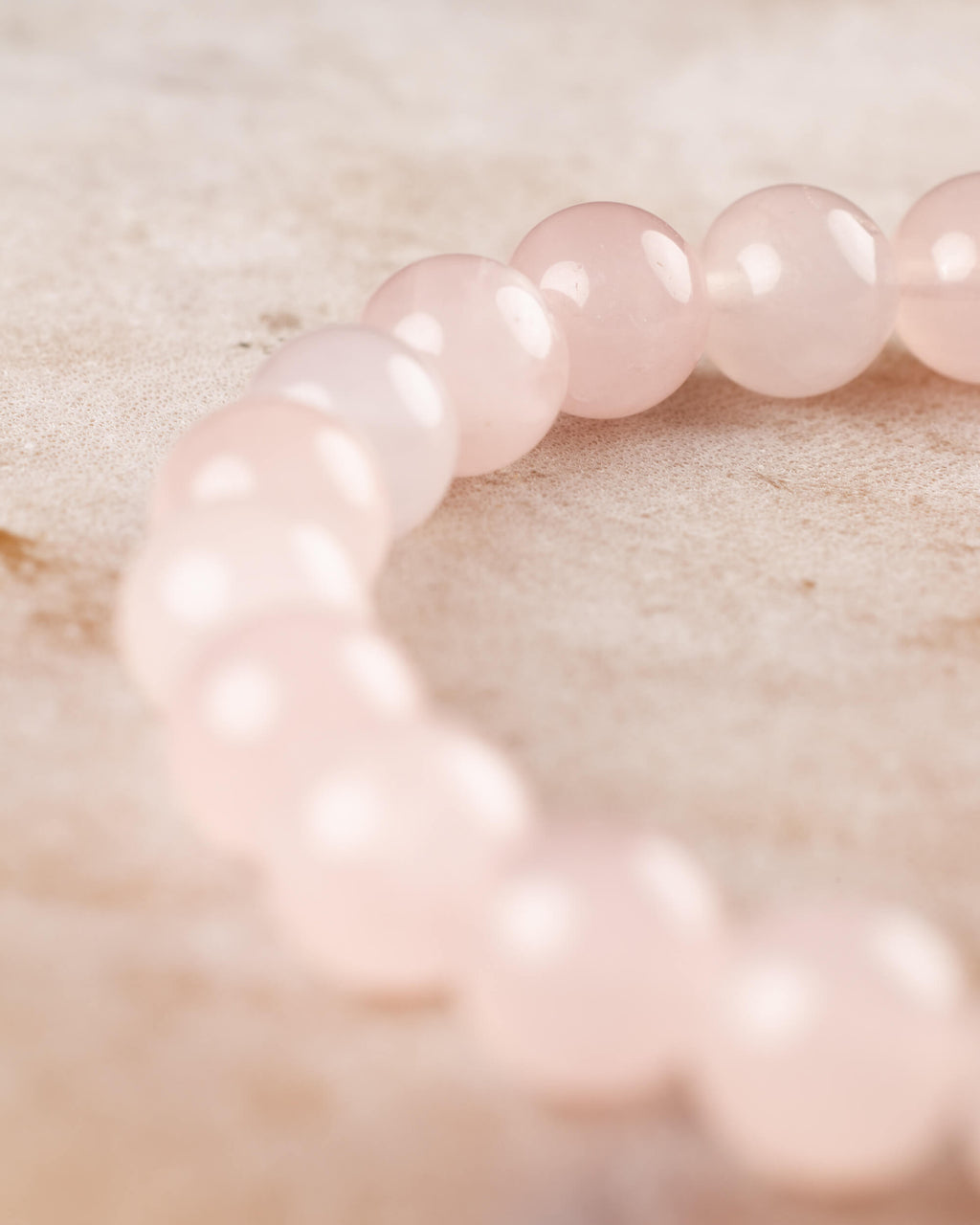 Pulsera de Cuarzo Rosa mostrando la curva de cuentas rosa pálido