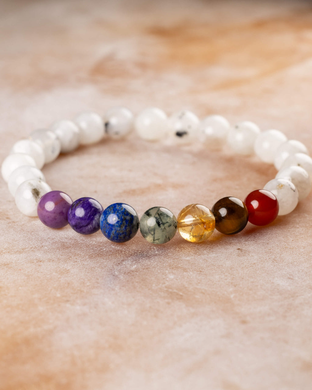 Pulsera Piedra Luna y 7 Chakras en curva, vista de perfil sobre superficie clara