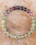 Pulsera de Fluorita multicolor, pieza completa en círculo sobre superficie de mármol claro