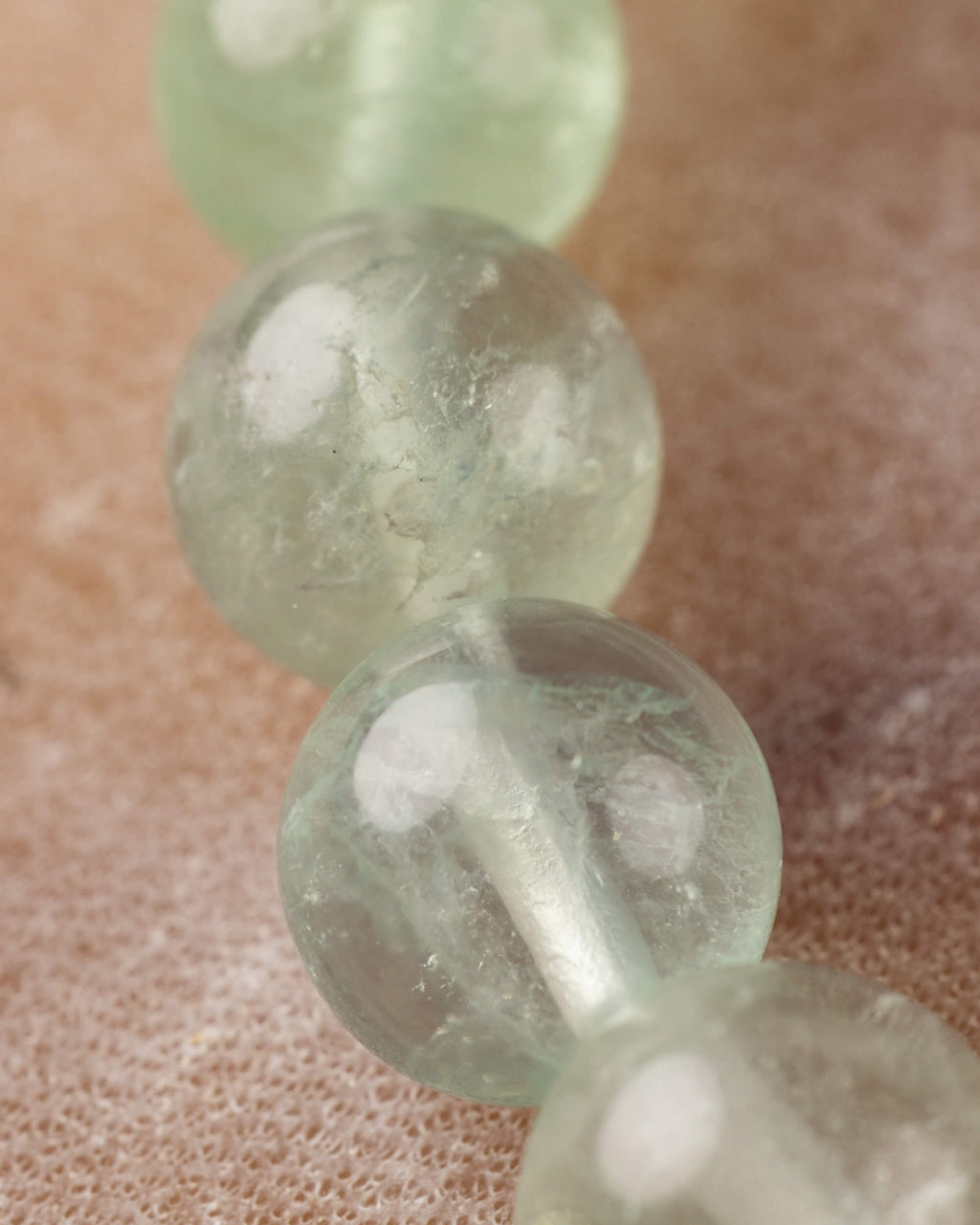Detalle macro de cuentas verdes translúcidas de Fluorita con vetas naturales