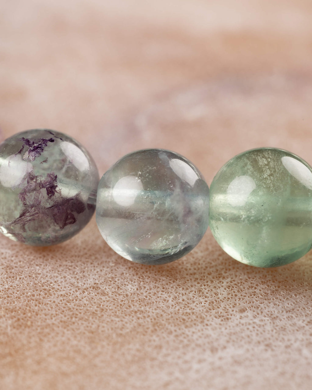 Cuentas de Fluorita en tonos morado y verde vistas de cerca, colores en degradado