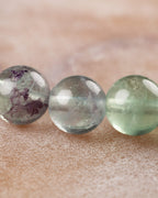 Cuentas de Fluorita en tonos morado y verde vistas de cerca, colores en degradado