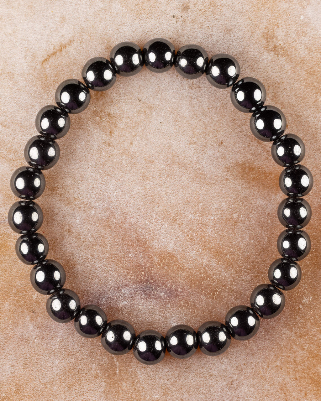 Pulsera de Hematita de 8 mm, pieza completa circular sobre superficie de piedra