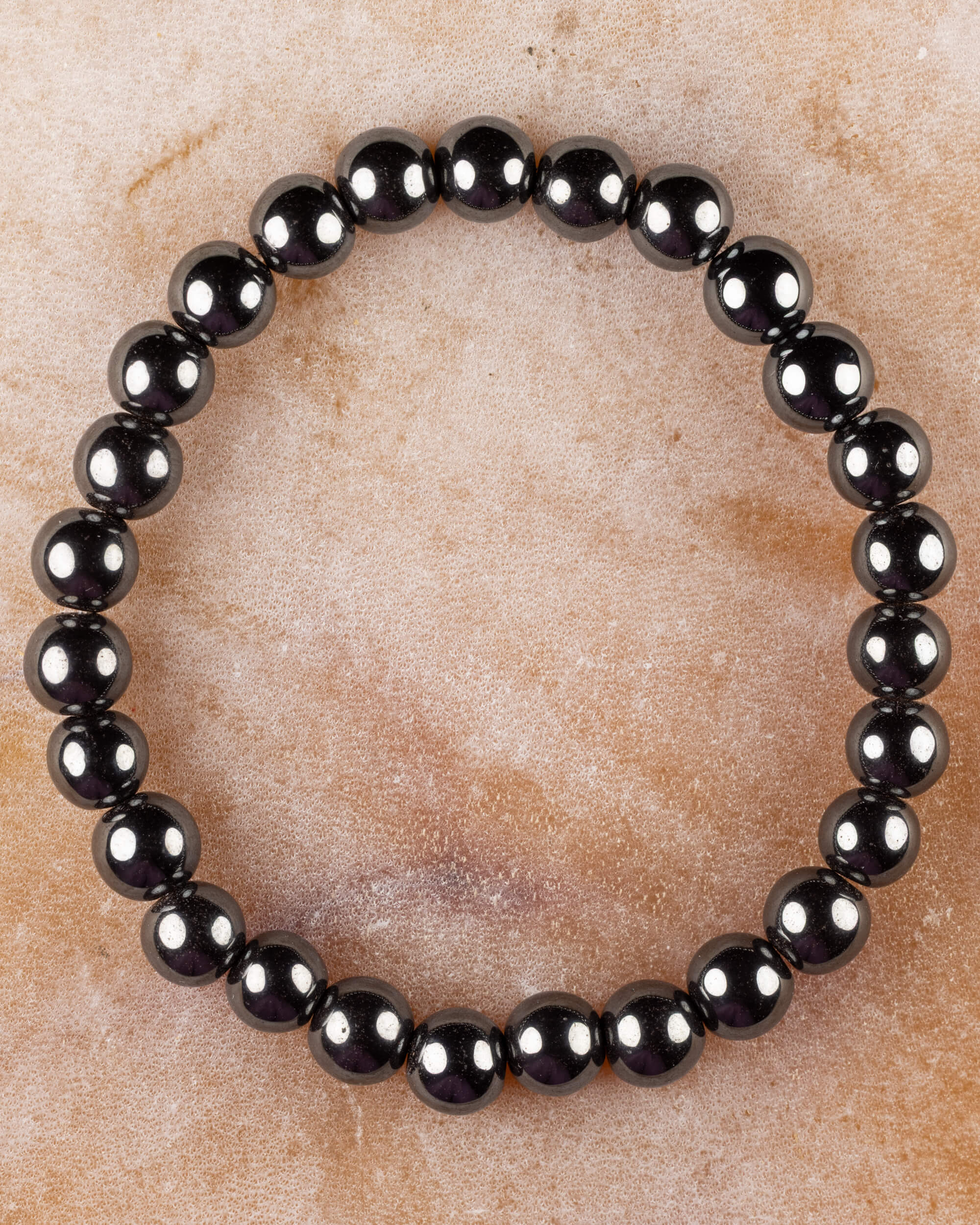 Pulsera de Hematita de 8 mm, pieza completa circular sobre superficie de piedra
