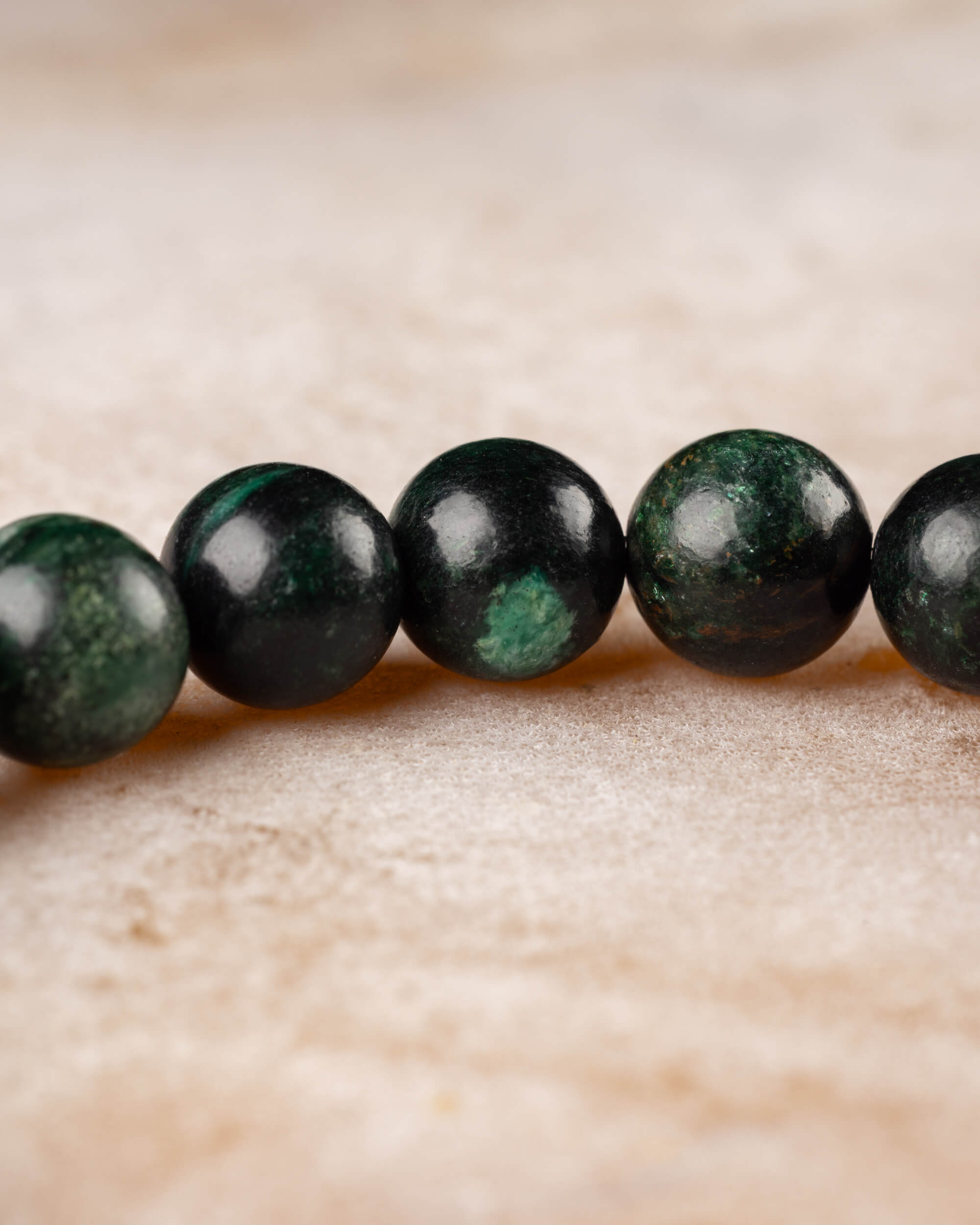 Cuentas verde oscuro con vetas de la Esmeralda en Matriz de Biotita en primer plano