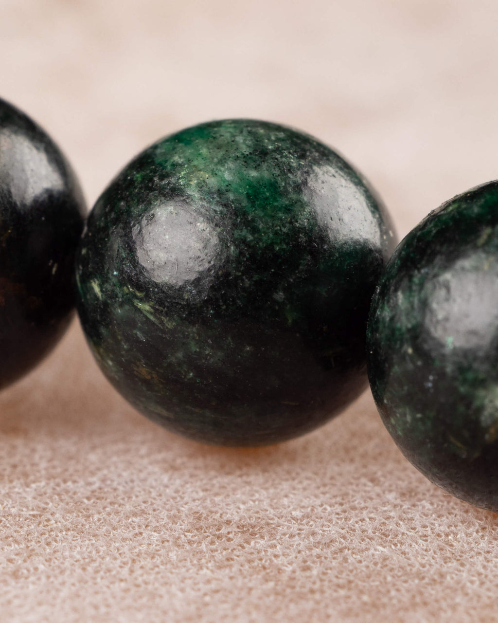 Detalle macro de una cuenta verde con vetas de la Esmeralda en Matriz de Biotita