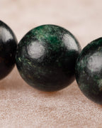 Detalle macro de una cuenta verde con vetas de la Esmeralda en Matriz de Biotita