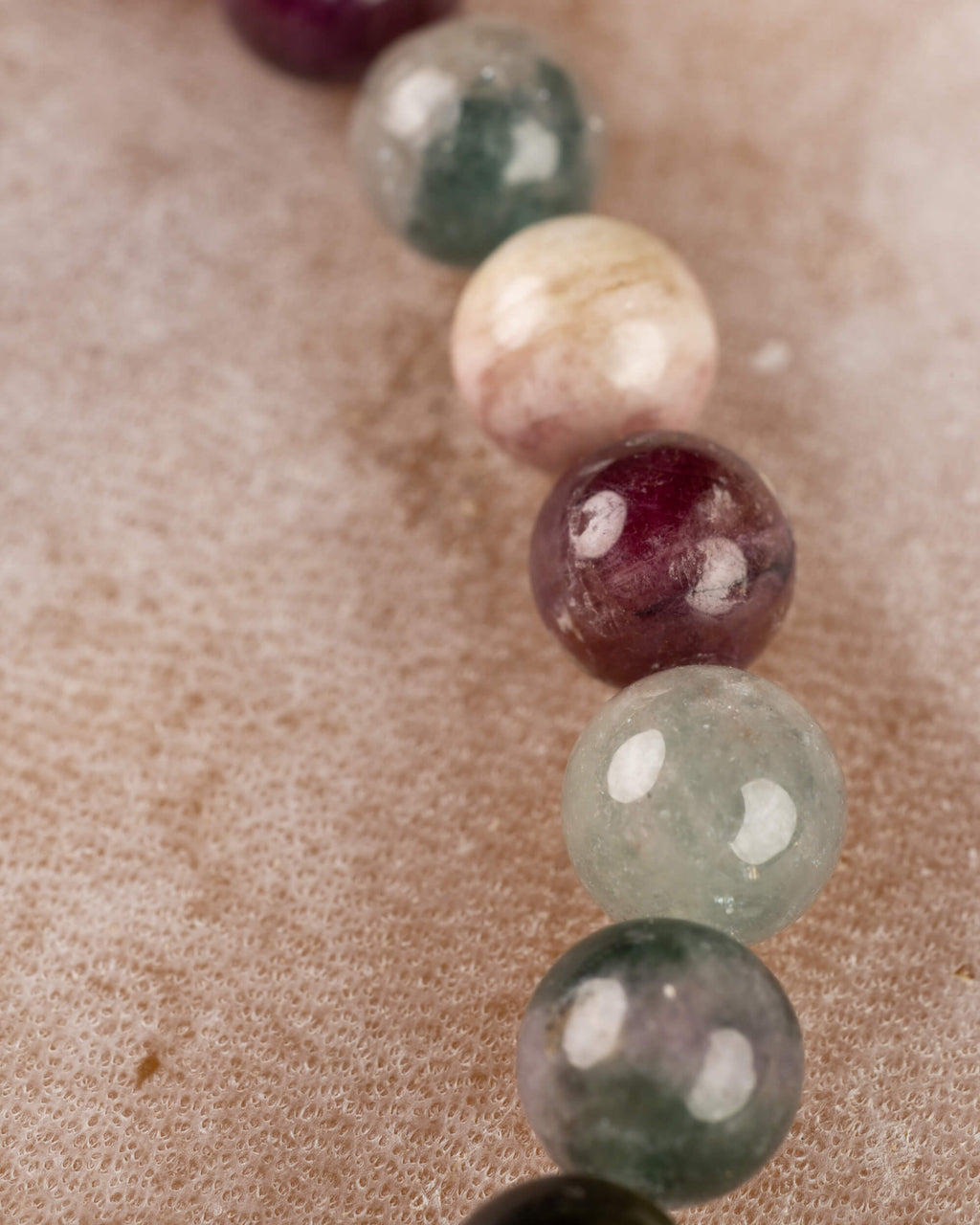 Detalle macro de cuentas de Turmalina en tonos crema, morado y verde