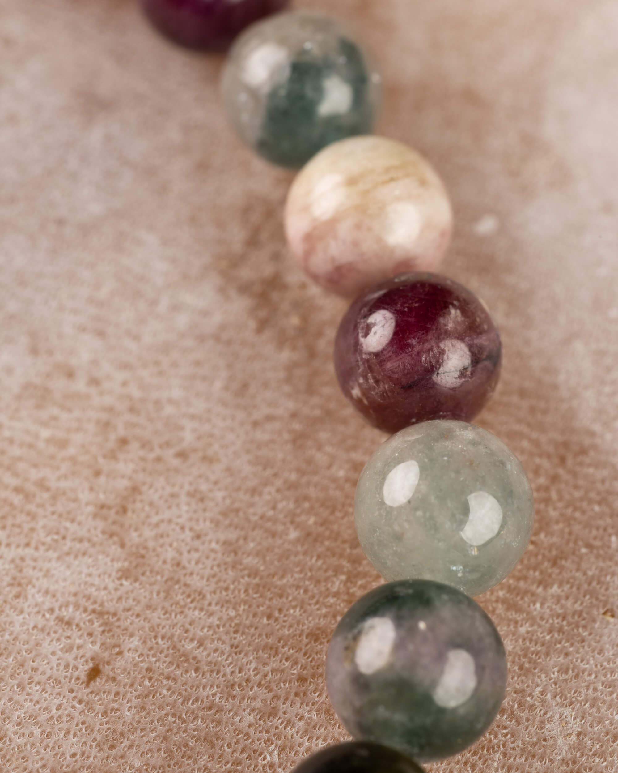 Detalle macro de cuentas de Turmalina en tonos crema, morado y verde