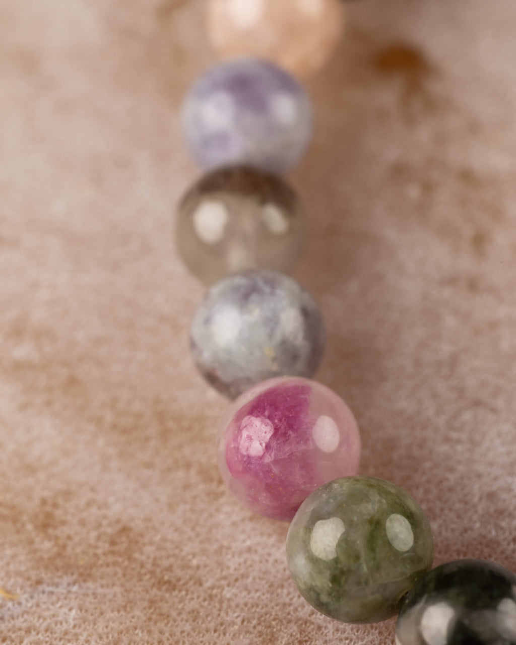 Detalle macro de cuentas de Turmalina con tonos lila, gris y rosa