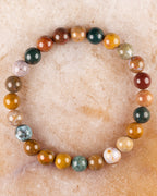 Pulsera de Jaspe Oceánico de 8 mm, pieza completa sobre superficie de piedra clara