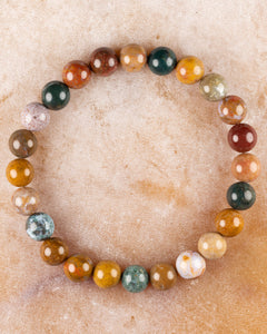Pulsera de Jaspe Oceánico de 8 mm, pieza completa sobre superficie de piedra clara
